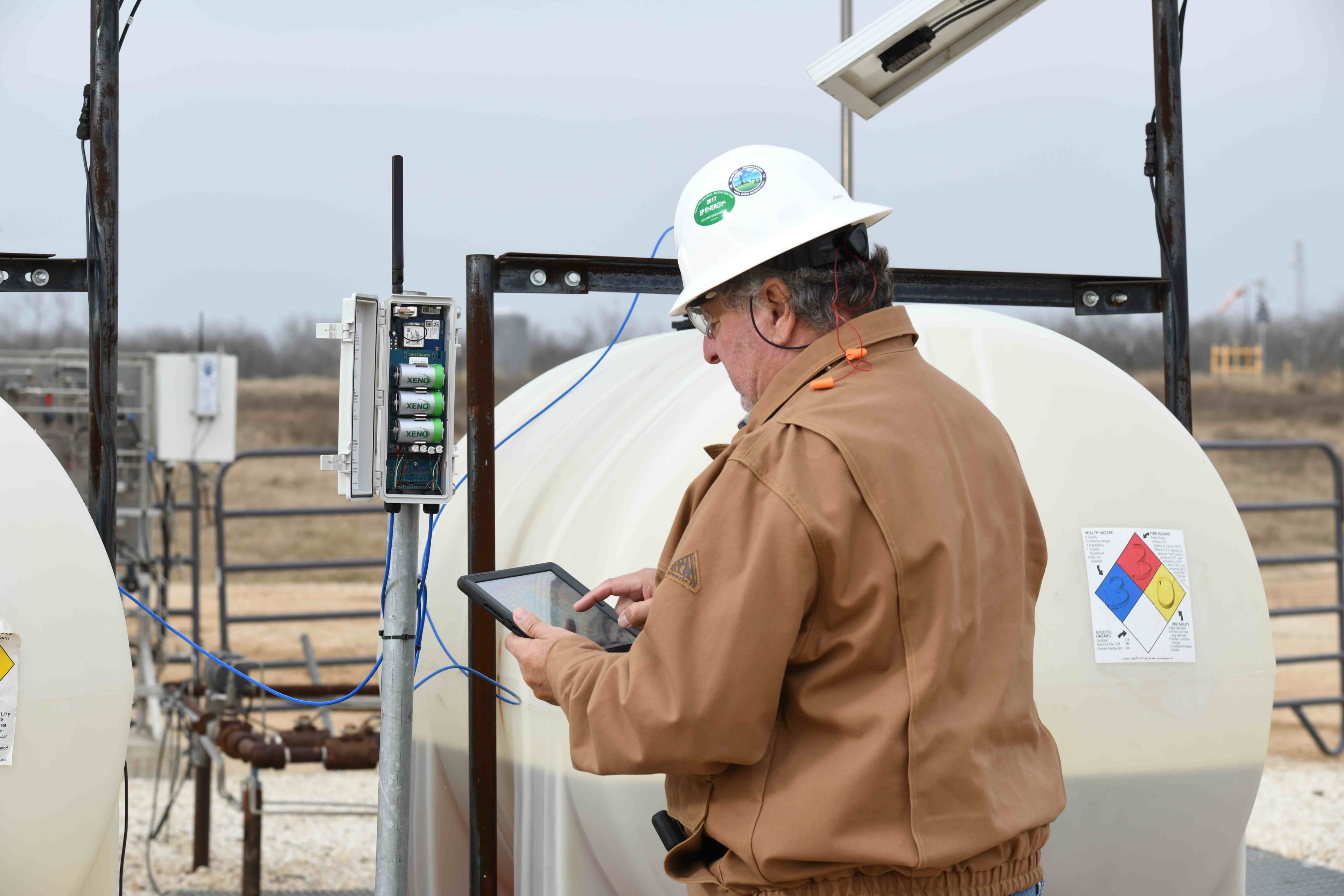 Field technician using iPad to monitor chemical tank data with WellAware equipment