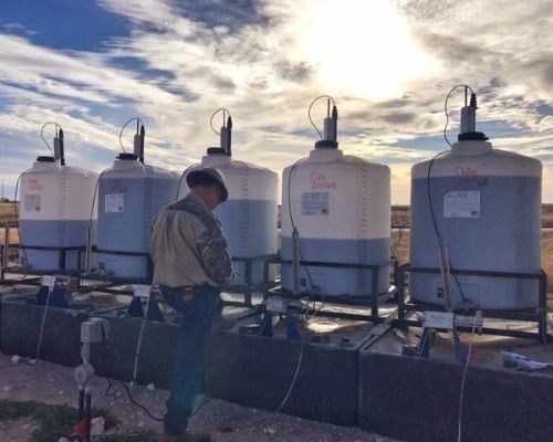 a chemical service technician checking chemical tanks at a midstream facility