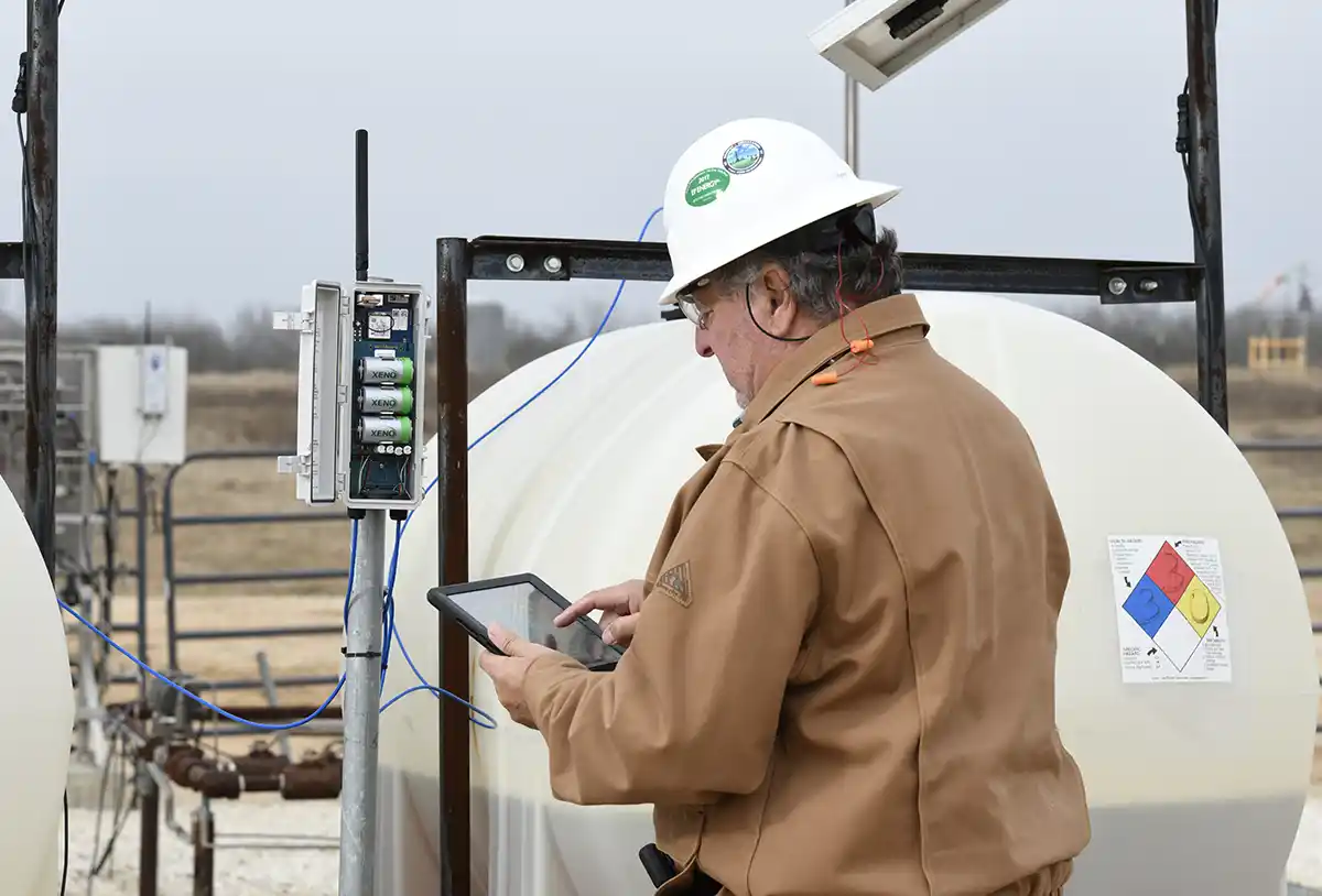 Image of a worker utilizing Wellaware and monitoring chemicals.